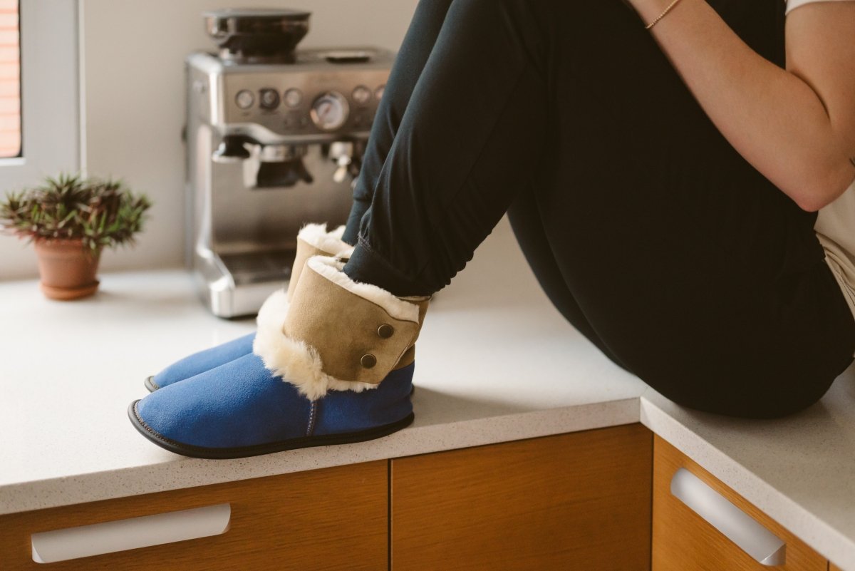 Femme portant des pantoufles en mouton à la cuisine