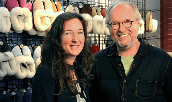 François et Noémi Garneau devant un assortiment de pantoufles de mouton. 